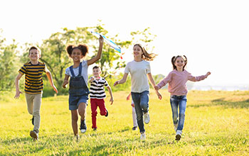 Cute little children running and playing with kite outdoors on sunny day